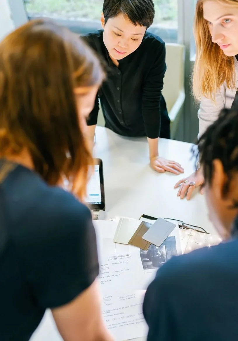 机を囲んで資料を見ながら話し合う人たちを上から見た様子